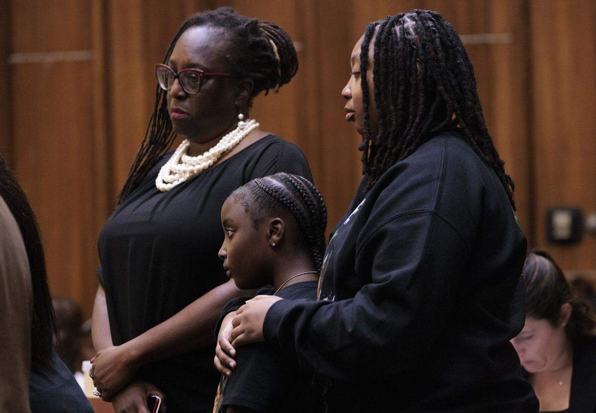 Melba Pearson, left, the Lollar family’s attorney, stands with Yahkeim Lollar’s sisters during their mother’s victim-impact statement on Tuesday, May 5, 2026. 